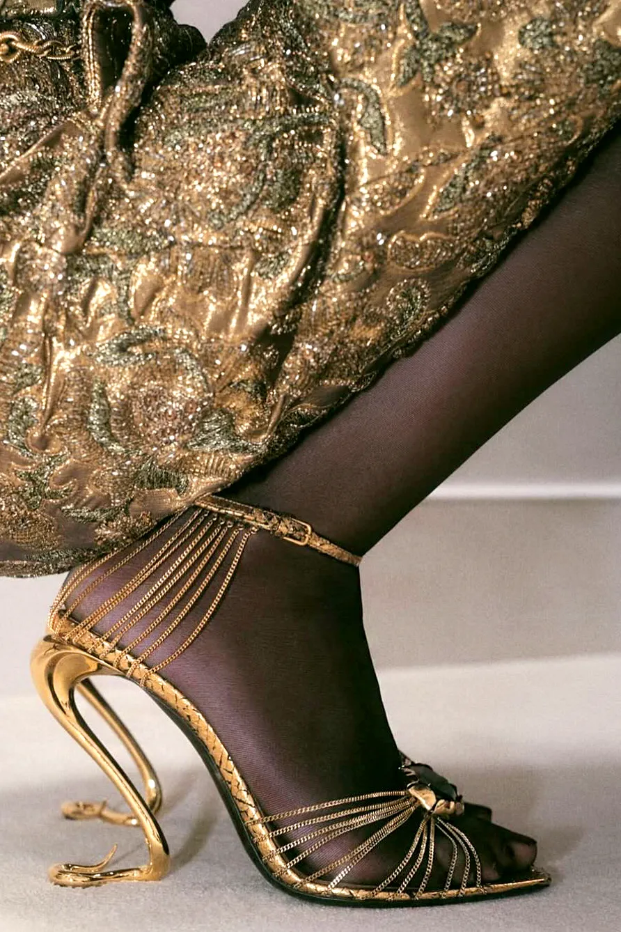 Saint Laurent gold chain sandal with a sculptural serpent heel